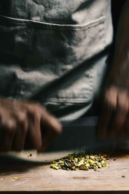 Hands chopping pistachios